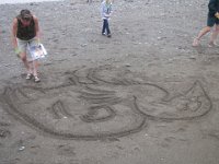 IMG 5128  Karin Bach, local artist sfinishing the sand outline for Tidal Art Program, Alma Beach, Fundy National Park